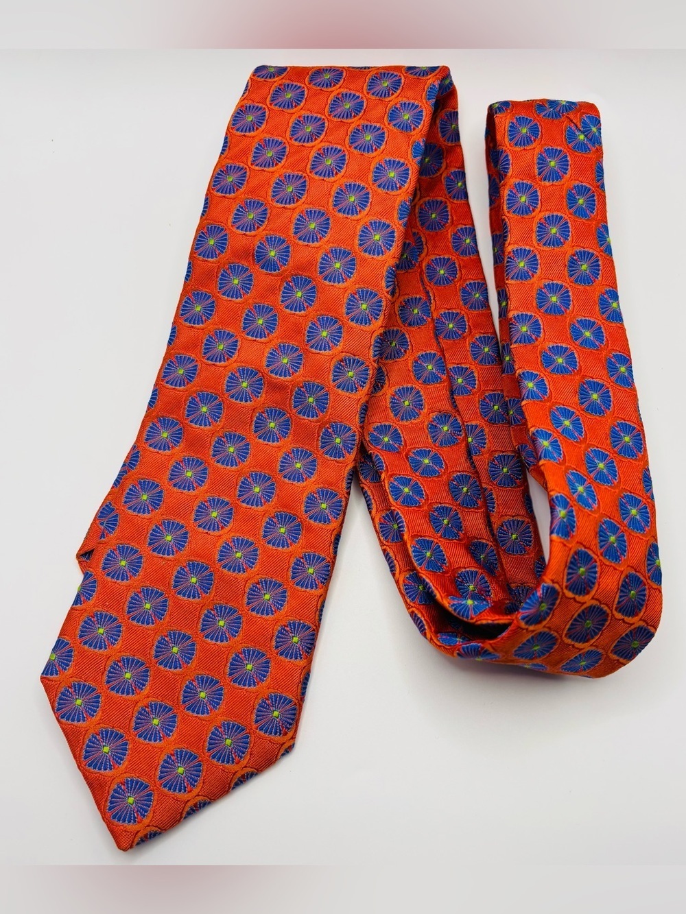 Ted Baker 100% silk orange tie with blue abstract botanical design.